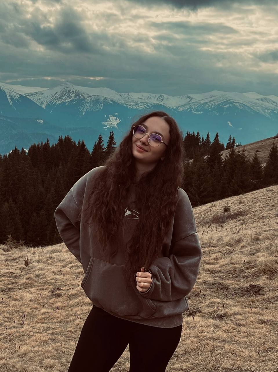 Kasia Lewandowska standing on a mountain with snow-capped peaks in the background